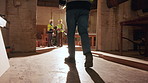Carpenter, legs and walking with timber in workshop, manufacturing and carpentry project management. Woodworking, artisan and person with lumber, flare and furniture production development in factory
