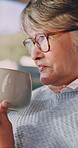 Senior, woman and thinking with coffee in retirement home for warm beverage or comfort. Thoughtful, elderly or female person with glasses, cup or mug for caffeine, morning drink or relax in house