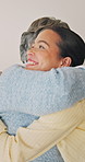 Family, hug and happy woman with senior mother on couch, excited and reunion with daughter in lounge. People, laughing and listening to good news, embrace and bonding with elderly parent in house