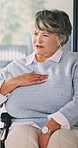 Senior, woman or wheelchair with chest pain in home for medical consultation or healthcare checkup. Elderly, patient or female person with a disability for health treatment, symptoms or cure in house