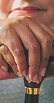 Senior, woman and hands with cane in house for retirement, mobility support or balance. Closeup, female person or elderly with walking stick for rehabilitation, parkinson or help in nursing home