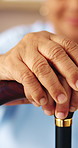 Senior, woman and hands with cane in home for retirement, support or balance in old age house. Closeup, elderly or female person resting with walking stick or aid for movement, comfort or mobility