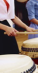 People, hands and learning with drums in class for music production, sound or taiko tradition. Group, instrument and playing with sticks for percussion rhythm, culture or musical audition together