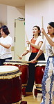 Taiko, creative and women with drums for practice, rehearsal or learning cultural choreography. Bachi percussion, lesson and people in Japanese band for sound coordination, performance or rhythm.