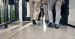 Legs, walking and business people with bag in office building for commute, travel or leaving. Back view, group or employees moving with team in workplace for career or job opportunity in hallway