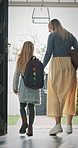 Leaving, mom and girl at front door in home ready for school, work and commute together. Family, house and back of mother and child holding hands for education, career or morning routine to start day