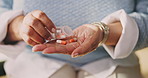 Hands, medication and woman with pills in home for medical treatment, wellness or prescription. Medicine, healthcare tablets and person in house with vitamins, capsules or supplements for recovery.