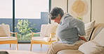 Senior, woman and back pain on sofa, injury or fibromyalgia with osteoporosis in living room. Discomfort, retirement or person with sore spine at home, arthritis or muscle tension with health problem