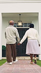 Senior, couple and walk outdoor with new home, holding hands and real estate investment for retirement. Back, married old black people and talk in front yard with relocation, mortgage and dream house