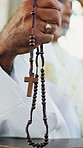 Hands, praying and man with rosary in church for spiritual service, catholic prayer and gratitude. Worship, religion and mature person with crucifix for hope, faith or respect with gospel in chapel
