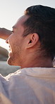 Beach, laugh and man on vacation, relax and enjoy view with sunshine on summer trip outdoor. Smile, tropical holiday and person in nature by seashore for tourism, sightseeing and funny joke on break