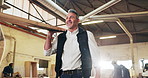 Carpenter, man and carry wood in workshop with smile, manufacturing operations and woodwork process. Flare, happy mature person and walk with timber, lumber production or manual labor from low angle.