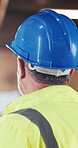 Construction, hardhat or man on site with inspection, risk control or safety in building project. Protection, back or builder with helmet, ppe compliance or hazard prevention in industrial evaluation