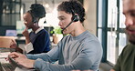 Call center, man and laptop with colleagues in office, contact us and communication with help desk. Person, coworking and typing at pc for online advice, customer support and telecom in workplace