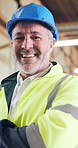 Crossed arms, man and face of construction worker on site with confidence for building repairs. Happy, about us and portrait of mature civil engineer with pride for renovation, maintenance or project