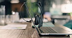 Empty, desk and laptop with headset for customer service communication and contact us at call center. Help, advice and workspace with computer, audio technology and client support with telecom