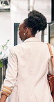 Walking, thinking and back of business black woman in office for commute, reflection and arrival. Perspective, journey and mindset with employee in agency for time management and appointment