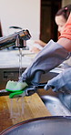 Parent, hands and washing dishes in home for routine, soap and disinfection in kitchen cleaning. Person, daughter and teaching child responsibility or support, bonding and housework for hygiene