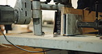 Saw, machine and hands of carpenter in workshop for carpentry, wood project and process with plank. Woodworking, handyman and person with tools for manufacturing, joinery warehouse and equipment