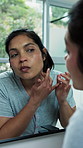Woman, inspection and mirror in home for skincare, pimples and breakout for skin irritation. Person, reflection and check in bathroom for facial blemish, clogged pores and acne for dermatology issues