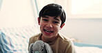 Face, hug and little boy with teddy bear in bedroom of home for comfort, love or security. Child development, morning and smile with happy kid embracing stuffed animal on bed in apartment for care