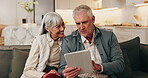 Tablet, talking and senior couple on home sofa with internet connection, discussion and bonding. Man, woman and technology on living room couch for planning, app or explain pension on retirement blog