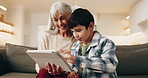 Grandma, child and tablet in house for learning, play game and bonding together on weekend. Tech, smile and boy with grandparent on sofa for educational gaming, scroll app and online development