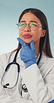 Doctor, thinking and woman with doubt in studio, remember choice and planning for healthcare service. Blue background, medical professional and person with health decision, thoughts and reflection
