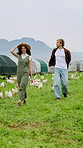 Farmer, walking and happy couple on poultry farm for agriculture or trip together in countryside. Man, woman and chickens with smile for livestock, farming or food production on farmland in nature