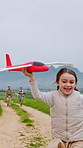 Happy, girl and playing with airplane in nature for fun childhood, weekend or imagination. Mom, dad and daughter with smile or aeroplane in countryside for playful holiday, development or freedom