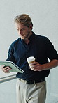 Businessman, walk and tablet in office with coffee, reading company news or check email notification. Person, morning drink and online in workplace with tech, review proposal or internet connectivity
