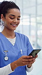 Nurse, woman and typing in hospital with phone, telehealth website and smile for text message alert. Happy, person and scroll in clinic with tech, reading medical news and mobile app for healthcare.