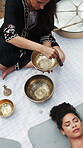 Meditation, practitioner or woman with tibetan bowl, spiritual practice or zen in holistic session. Above, healer or client with instrument, sound therapy or grounding vibration in wellness treatment