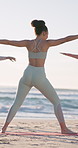Yoga class, beach and back of woman with stretching, exercise or wellness routine in morning on holiday. Health, outdoor and person by ocean for fitness, active and pilates by seaside on weekend trip