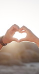 Couple, unity and outdoor with heart hands for bonding together, care and romantic anniversary date. Sun flare, space and people in nature with love emoji, trust and support for relationship partner.