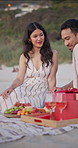 Smile, couple and relax at beach for picnic, love and romantic anniversary for summer holiday. Happy, people and discussion at sea with fruit platter, getaway date and partner celebration on vacation