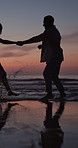 Couple, sunset and running at beach with holding hands, water splash and playful on romantic vacation. Man, woman and travel at ocean with bonding, summer holiday or hug on tropical coast in evening