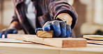 Sanding, carpenter and hands with plank in workshop for project, planning and manufacture furniture. Warehouse, sandpaper and person with equipment, timber material and small business in factory