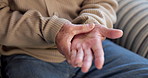 Senior, man and hands with pain in home for carpal tunnel syndrome, muscle tension or ache. Elderly, male person or patient with sore wrist or injury for joint inflammation or fibromyalgia in house