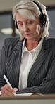 Writing, call center and businesswoman in office with crm, help desk or voip system for advice. Headset, notes and mature technical support consultant for customer service or online consultation.
