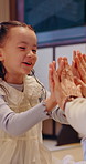 Hands, game and child with parents in home for bonding, learning song and playing together. Asian family, happy and girl with mom, dad and playful relationship for development, love and care in Japan