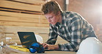 Carpentry, typing and man on laptop in workshop for furniture order, building schedule and email. Carpenter, business and person on computer for planning, report and timber inventory for woodworking