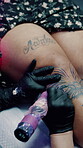Creative, hands and tattoo on leg in shop, skills and artist with client for ink design or aesthetic. Unique, process and person with equipment for body art, self expression and identity in store