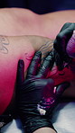 Artist, hands and tattoo on leg in shop, aesthetic and creative ink design with equipment or skills. Needle, sketch and person with tool for self expression, outline and client with body art in store