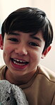 Face, laughing and little boy with teddy bear in home for child development, comfort or security. Adorable, cute and funny kid with stuffed animal in apartment for care, emotional support or growth