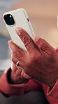 Typing, phone and hands of old man on sofa in home for bingo app, social media or chat. Text message, gaming subscription and virtual dealer with senior person in living room of house for connection 
