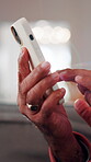 Scroll, phone and hands of old man on sofa in home for bingo app, social media or chat. Text message, gaming subscription and virtual dealer with senior person in living room of house for connection 