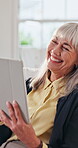 Senior woman, laughing and relax with tablet in lounge, reading or funny ebook with app subscription. Happy, mature person and chilling with technology, online and review novel on website in house