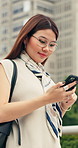 Phone, typing and woman in city with texting, email or research on finance growth for investment. Happy, walking and Asian financial advisor with cellphone for feedback on revenue report in town.