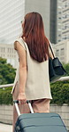 Woman, travel and walking with suitcase in city for commute, job opportunity or tourism. Back view, female person or traveler with luggage or bag in an urban town for journey or road trip on sidewalk